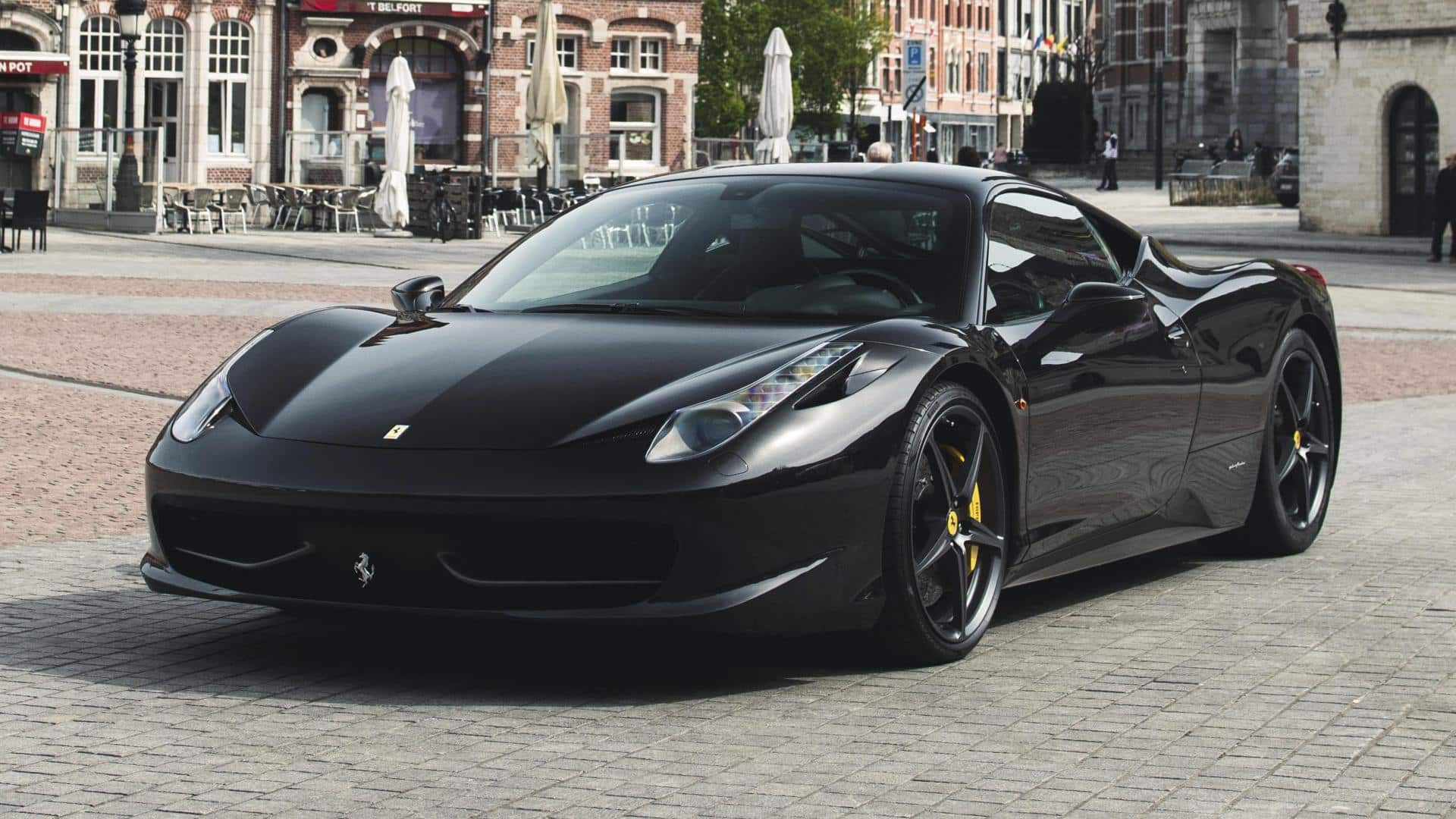Black Ferrari 458 Italia front three-quarter view on urban street